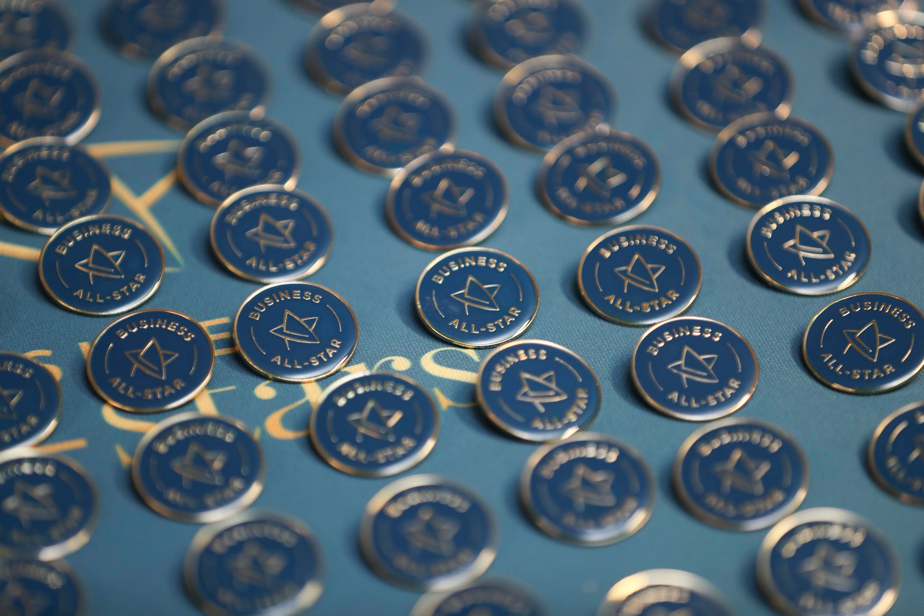 Blue and gold medals for the Business All-stars of Ireland on a blue tabletop