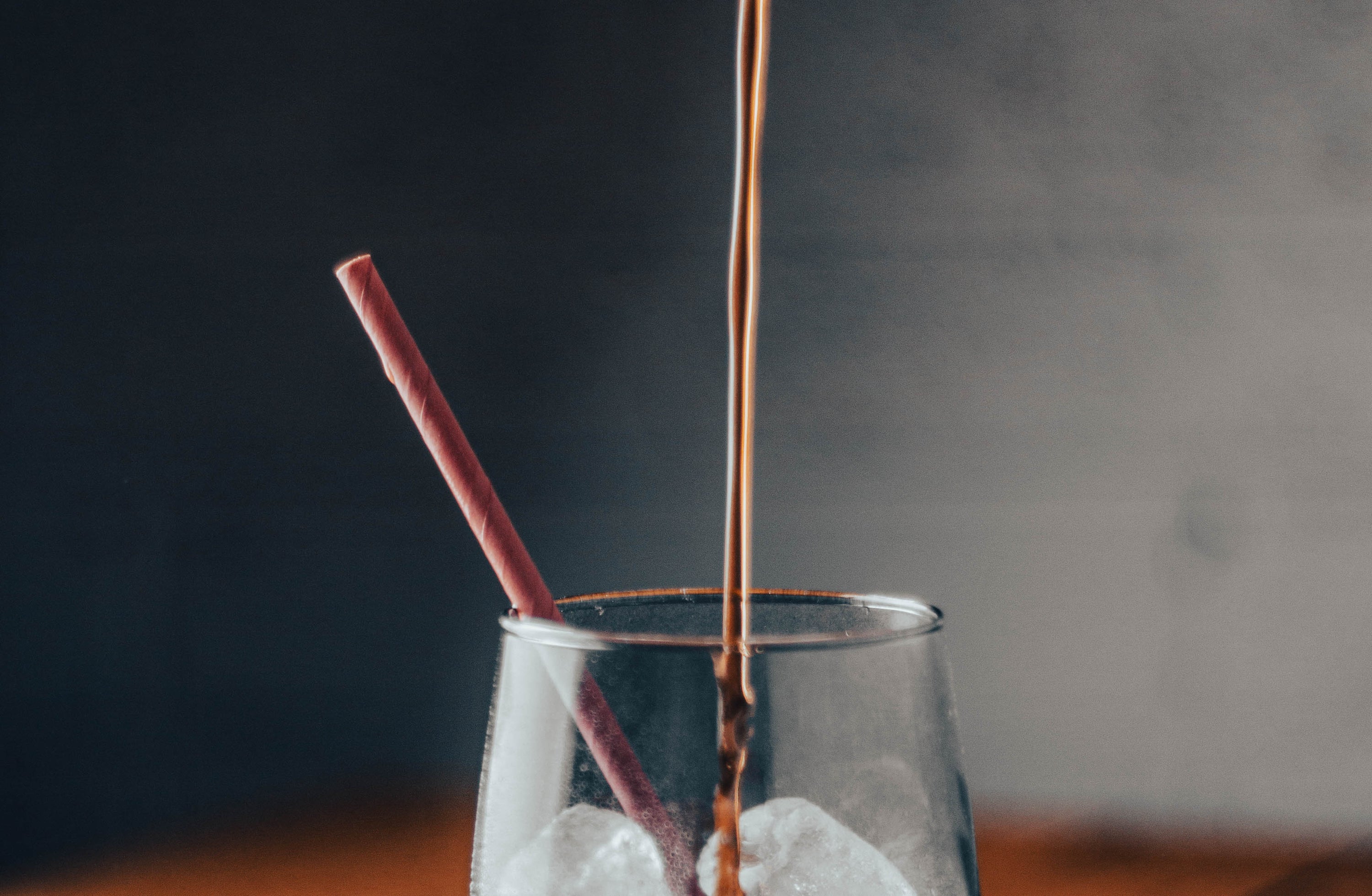 Iced coffee pouring into a glass filled with ice