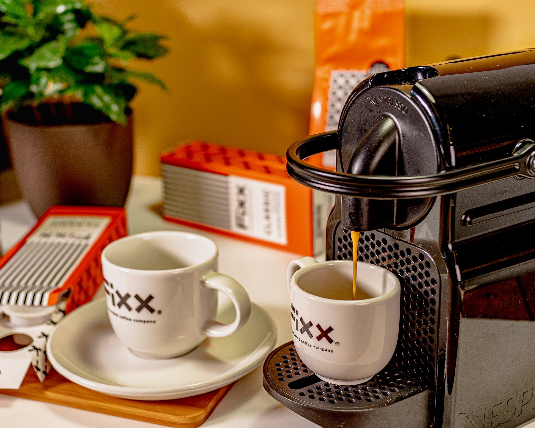 Coffee pouring from a coffee capsule machine into a FiXX Coffee cup.