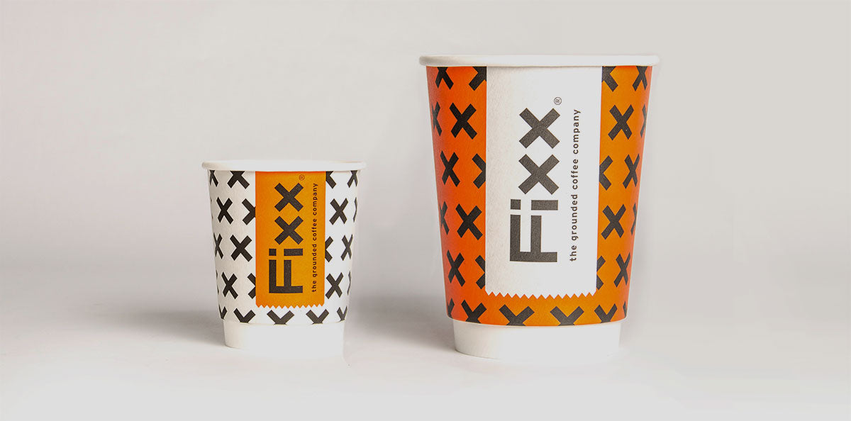 Two orange, white and black FiXX Coffee take away cups.