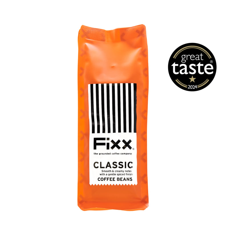A package of Fixx Classic coffee beans in an orange bag with black and white stripes, and a &