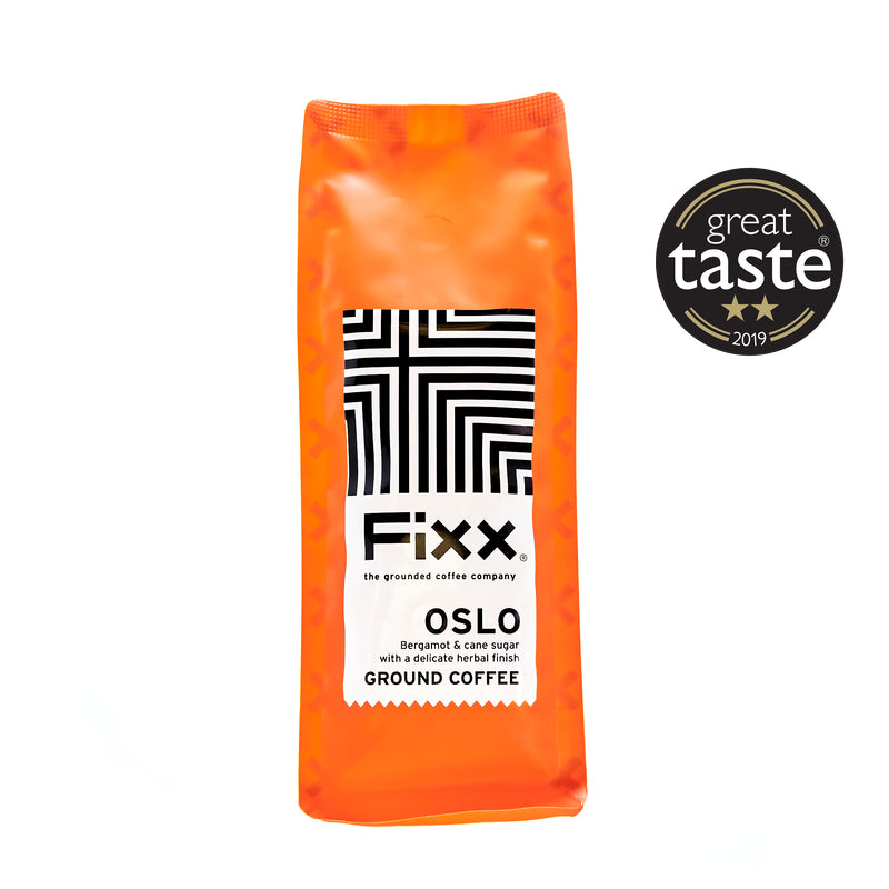 A pack of FiXX Oslo ground coffee beans with bright orange packaging and a black and white geometric design. It has a label indicating it&