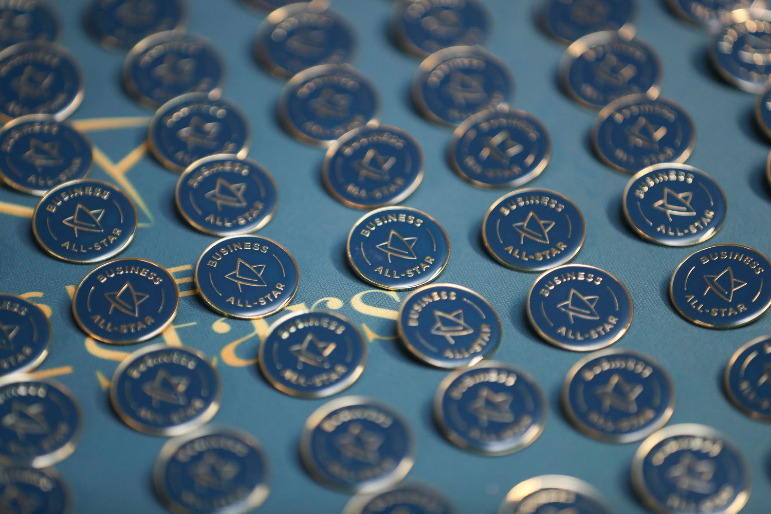 Blue and gold medals for the Business All-stars of Ireland on a blue tabletop 