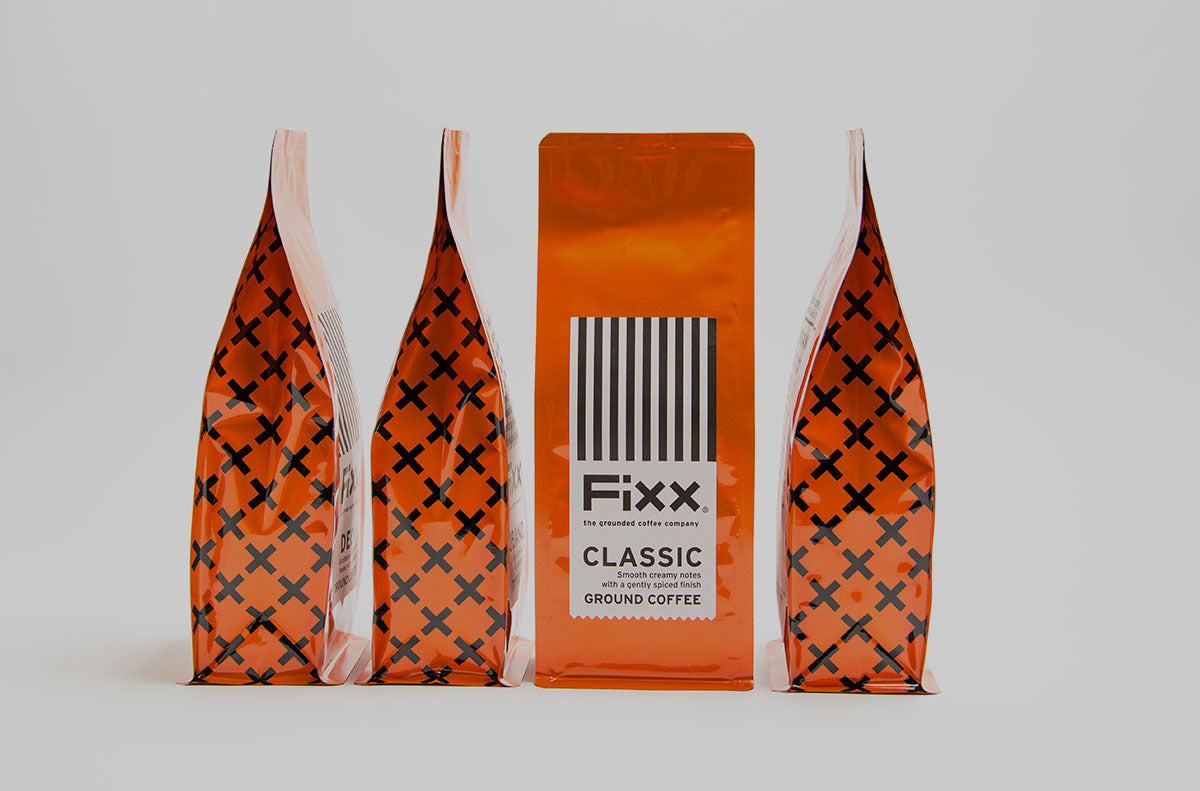 Four vibrent orange FiXX Coffee bags side by side.
