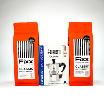 Two orange bags of Fixx Classic Coffee Beans flanking a white and blue Bialetti Oceana Moka Express coffee maker box, set against a clean white background.