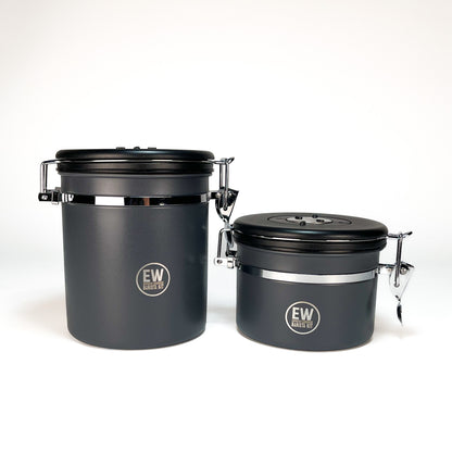 Two black storage containers with black lids on a white background, featuring the &