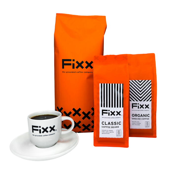 Orange Fixx coffee bags and a white cup with coffee on a white background
